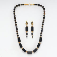 Eykaa brand necklace and earrings that feature semi precious stone black onyx with hakik  on a white background 